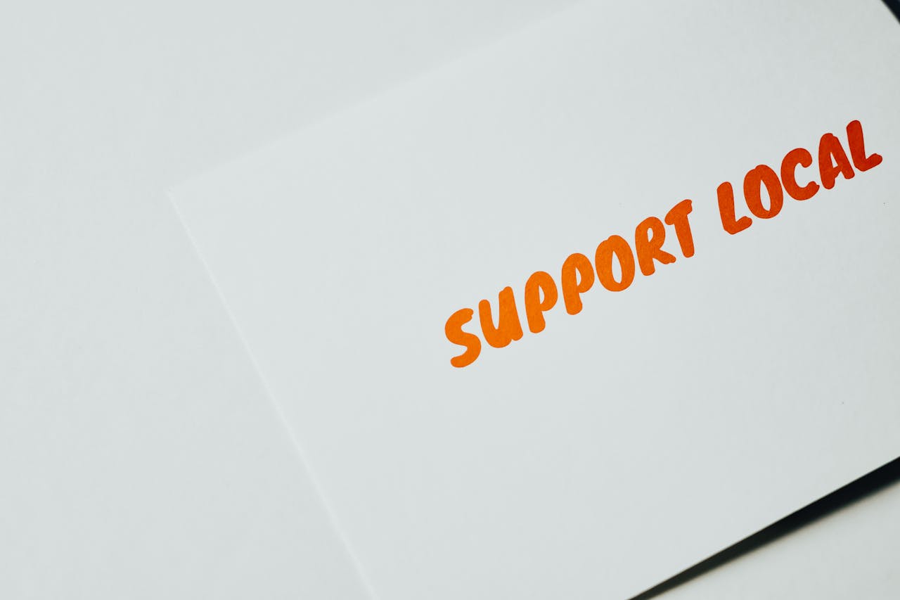 gallery-1 Close-up of 'Support Local' message on white paper, encouraging local support.